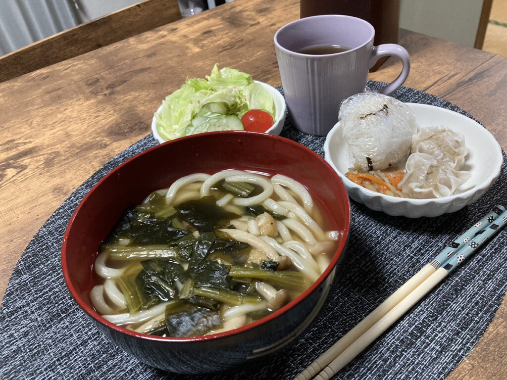 ちるほーむの食事。うどん、おにぎり、シュウマイ、小鉢とサラダ